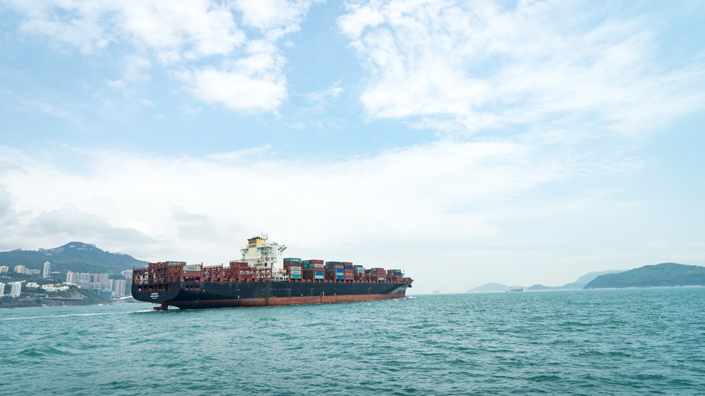 A shipping tanker, or vessel, full of shipping containers for international trade.